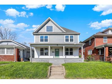 Charming two-story home featuring a covered front porch and freshly cut green lawn at 3628 N Illinois St, Indianapolis, IN 46208