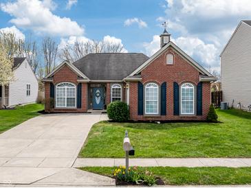 Charming brick home with a well-manicured lawn, blue door and shutters, and concrete driveway at 4729 Beach Club Dr, Noblesville, IN 46062