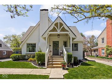 Charming white brick home with a gable roof, landscaped yard, and inviting covered front porch at 5946 N New Jersey St, Indianapolis, IN 46220