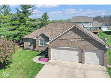 Lovely brick home featuring an attached two-car garage and blossoming landscaping at 6232 Buck Trail Rd, Indianapolis, IN 46237