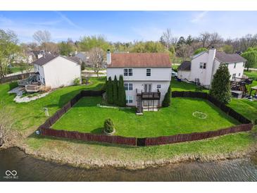 Beautiful backyard with a wooden deck, a fenced lawn and views of the pond at 6514 Trevia Ct, Indianapolis, IN 46236