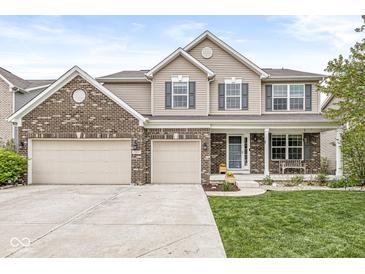 Charming two-story home featuring a three-car garage, brick accents, and a welcoming front porch at 7829 Hedgehop Dr, Zionsville, IN 46077