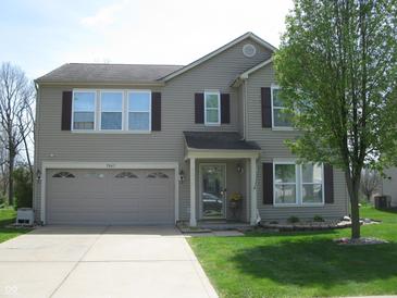 Charming two-story home with a well-manicured lawn, attached garage, and neutral-colored siding at 9045 Stones Bluff Pl, Indianapolis, IN 46113