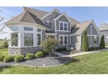 Attractive two-story home featuring stone accents, meticulous landscaping, and a cozy front bench at 1051 Margate Dr, Greenwood, IN 46143