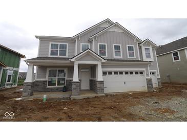New two-story home with gray siding, stone accents, covered porch, and two-car garage awaiting its landscaping at 12417 Fresh Stock Dr, Noblesville, IN 46060
