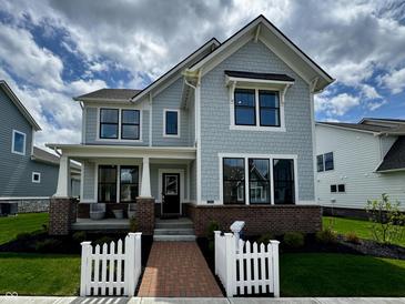 Charming two-story home featuring a covered front porch, brick accents, and a manicured front lawn at 1285 Chatham Hills Blvd, Westfield, IN 46074