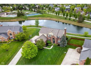 Stunning aerial view of home with large yard, pond, pool, and tennis courts in desirable community at 14145 Charity Chase Cir, Carmel, IN 46074