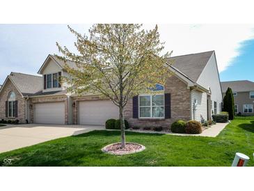 Charming two-story brick home with a well-manicured lawn and a three car attached garage at 1435 Colony Park Dr, Greenwood, IN 46143