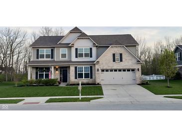 Charming two-story home with a manicured lawn, brick accents, and a two-car garage, presenting an inviting curb appeal at 5529 W Turnbuckle Pl, McCordsville, IN 46055