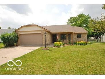 Charming single story home with a well maintained lawn, attached garage and welcoming front porch at 7450 Cobblestone W Dr, Indianapolis, IN 46236