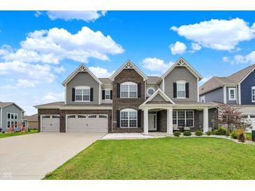 Beautiful two-story home with brick and siding, three-car garage, and well-manicured lawn at 10811 Wild Orchard Ln, Indianapolis, IN 46239