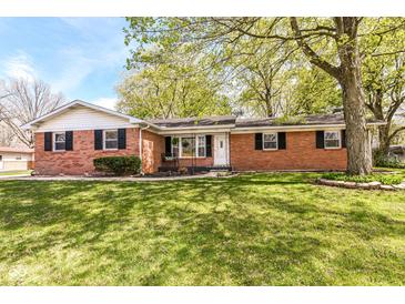 Charming single-story brick home featuring a well-manicured lawn and mature trees at 11359 Peacock Dr, Indianapolis, IN 46236
