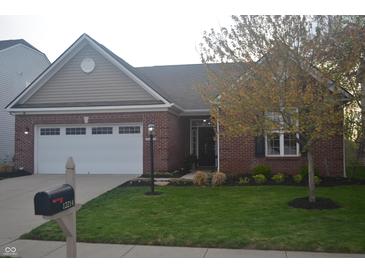 Charming brick home featuring an attached two-car garage, well-manicured lawn and mature landscaping at 12214 Cold Stream Rd, Noblesville, IN 46060