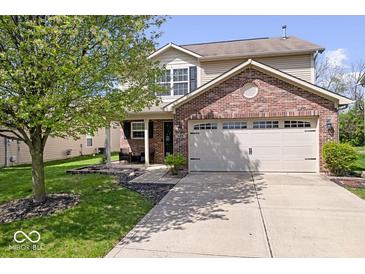 Charming home with a brick front, attached two-car garage and mature tree in the front yard at 132 Thistlewood Dr, Greenfield, IN 46140