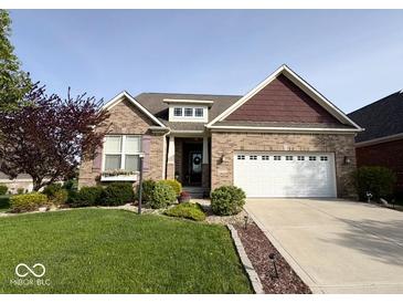Charming brick home with a well-manicured lawn, landscaping and a two-car garage in a suburban neighborhood at 18756 Brookston Ln, Noblesville, IN 46062