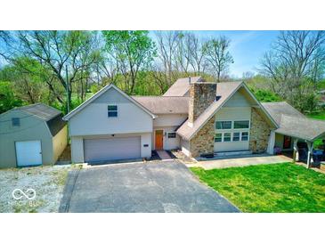 Charming home with stone chimney, two-car garage, and well-manicured lawn, perfect for suburban living at 260 17Th St, Columbus, IN 47201