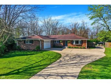 Charming brick home with a well-manicured lawn and a long driveway on a sunny day at 360 Hope Ct, Greenwood, IN 46142