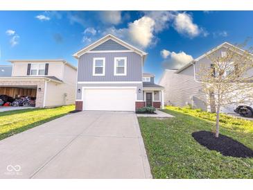 Charming two-story home with a white garage door, gray siding, and a well-manicured lawn at 4046 Denali Dr, Indianapolis, IN 46235