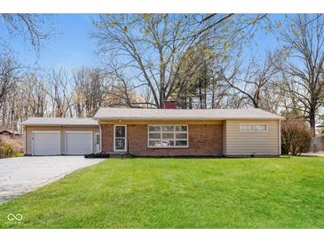 Charming single story home featuring a brick facade, attached garage, and a well-maintained front lawn at 9535 E Michigan St, Indianapolis, IN 46229