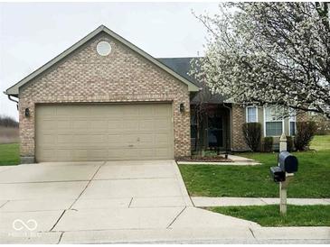 Charming brick home featuring an attached two-car garage and a well-manicured lawn at 9671 Trail Dr, Avon, IN 46123