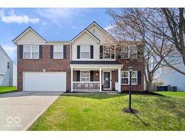 Charming brick two-story home with a well-manicured lawn and inviting front porch at 10883 Balfour Dr, Noblesville, IN 46060