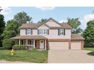 Charming two-story home with brick accents, shutters, and a well-maintained front yard and a two car garage at 13562 Silver Spur, Carmel, IN 46032