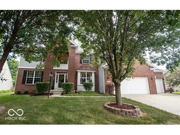 Charming two-story brick home featuring a well-manicured lawn and mature trees, creating an inviting curb appeal at 13717 Van Buren Pl, Fishers, IN 46038