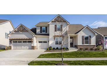 Charming two-story home with a manicured lawn, two-car garage, and beautiful architectural details at 15655 Woodford Dr, Westfield, IN 46074