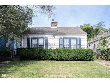 Charming home featuring a well-maintained lawn, blue shutters and a classic brick chimney at 270 S Lasalle St, Indianapolis, IN 46201