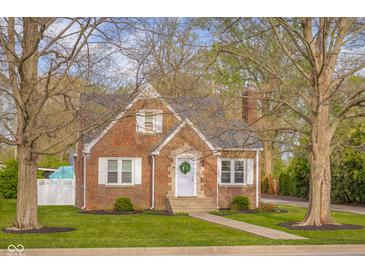 Charming brick home featuring a well-manicured lawn and inviting front porch at 3221 Washington St, Columbus, IN 47203