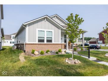 Charming single-story home with a brick foundation, a well-manicured lawn, and a cozy front porch at 360 Lincoln W Cir, Fortville, IN 46040