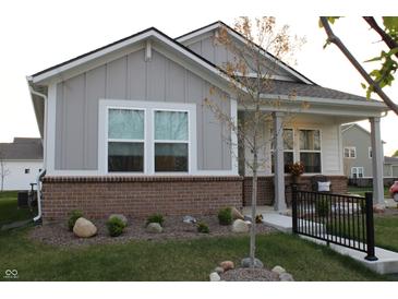Charming single-story home featuring stylish gray siding, a brick foundation, and a cozy front porch at 360 Lincoln W Cir, Fortville, IN 46040