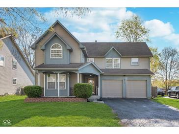 Charming two-story home with a well-manicured lawn and a two-car garage at 4917 Melbourne Rd, Indianapolis, IN 46228