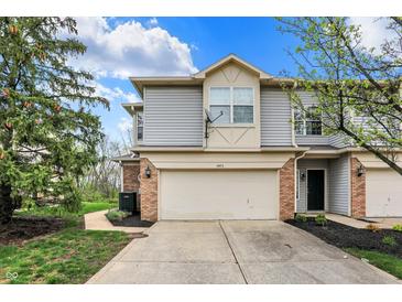 Two-story home showcasing neutral siding, brick accents, a two-car garage and a well-manicured front lawn at 5453 Nighthawk Way, Indianapolis, IN 46254