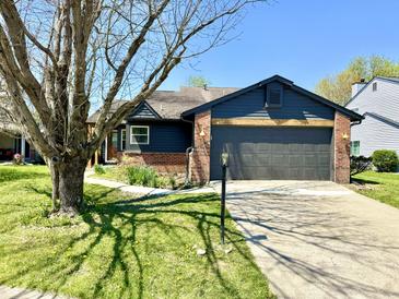 Charming home with a gray two-car garage, brick accents, and a well-manicured lawn at 653 Southridge Ct, Westfield, IN 46074