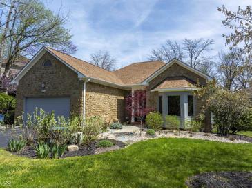 Charming stone home featuring an attached garage and beautifully landscaped front yard at 8069 Middle Bay Ln, Indianapolis, IN 46236