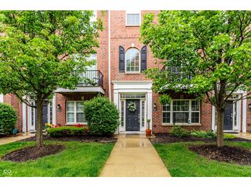 Charming brick townhome featuring a landscaped front yard and inviting entryway at 11905 Kelso Dr # 3, Zionsville, IN 46077