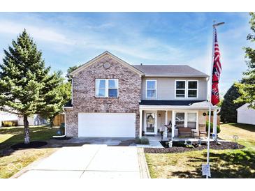 Charming two-story home featuring brick accents, a covered porch, and a well-manicured front yard at 12981 Coyote Run, Fishers, IN 46038