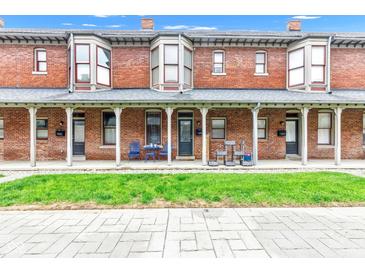 Attractive brick townhouse with covered porch and well-kept lawn at 1476 N Illinois St, Indianapolis, IN 46202