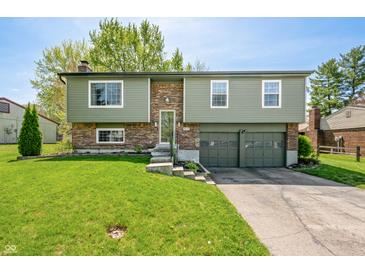 Charming split-level home with a well-manicured lawn and attached two-car garage at 3615 Dawnwood Dr, Indianapolis, IN 46227