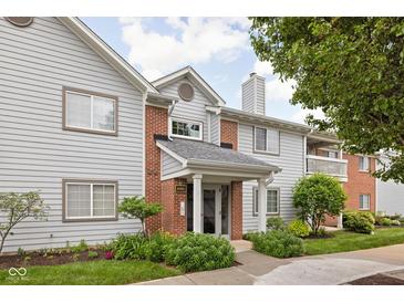 Inviting condo exterior featuring stylish siding, brick accents, and manicured landscaping at 8410 Glenwillow Ln # 208, Indianapolis, IN 46278