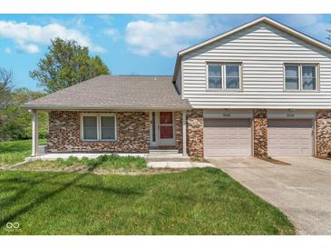 Charming two-story townhome featuring brick and siding exterior with an attached two-car garage at 9162 Cinnebar Dr, Indianapolis, IN 46268