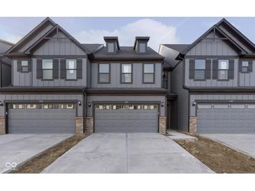 Modern townhome exterior showcasing stylish gray siding, dark trim, and convenient attached two-car garages at 9734 Behner Dr, Fishers, IN 46250