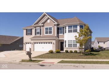 Charming two-story home with a three car garage, brick accents and manicured lawn at 1370 Timber Bluff Rd, Westfield, IN 46074