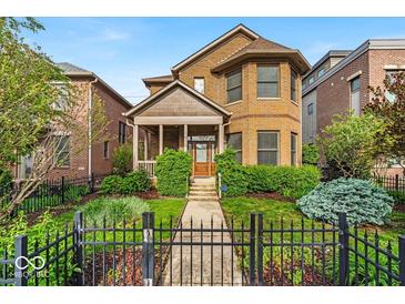 Charming brick home with manicured lawn and black fence in a desirable neighborhood at 1510 Central Ave, Indianapolis, IN 46202
