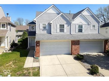 Charming home with an attached two car garage, gray siding, brick accents, and well-maintained landscaping at 1884 Misty Lake Dr, Indianapolis, IN 46260