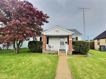 Charming single-story home with a walkway, mature tree, and well-maintained lawn at 2309 Pennsylvania St, Columbus, IN 47201