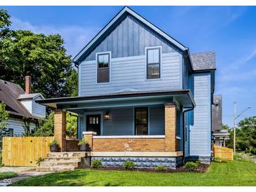 Charming two-story home featuring a covered front porch with brick supports and a well-maintained lawn at 3868 N Park Ave, Indianapolis, IN 46205
