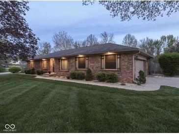 Charming single-story brick home with manicured lawn and landscape lighting for beautiful curb appeal at 4037 Hazy Ln, Greenwood, IN 46142