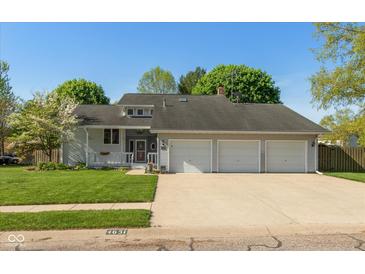 Charming single-story home featuring a three-car garage, covered porch, and well-manicured lawn at 4651 Monterey Dr, Columbus, IN 47203